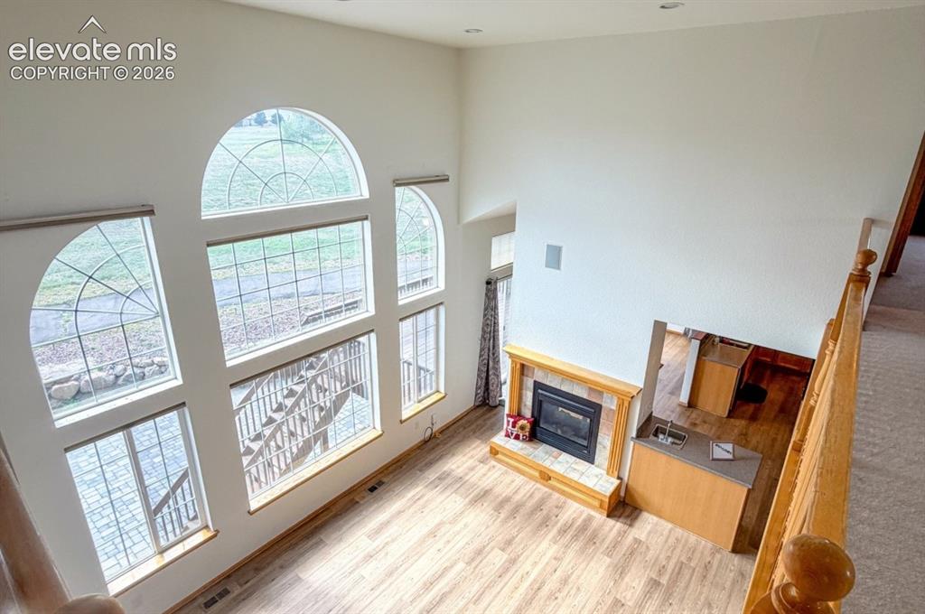 Image 21 of 48: Two-story vaulted ceiling with large arched windows, wood-finish flooring,