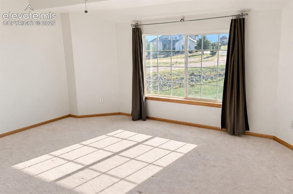 Image 26 of 48: Upstairs bedroom 1/3. Unstaged. Bright room featuring a large window, neutr