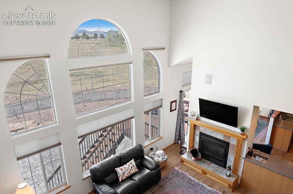 Image 27 of 47: Two-story living area featuring a wood-finish floor and a fireplace with a