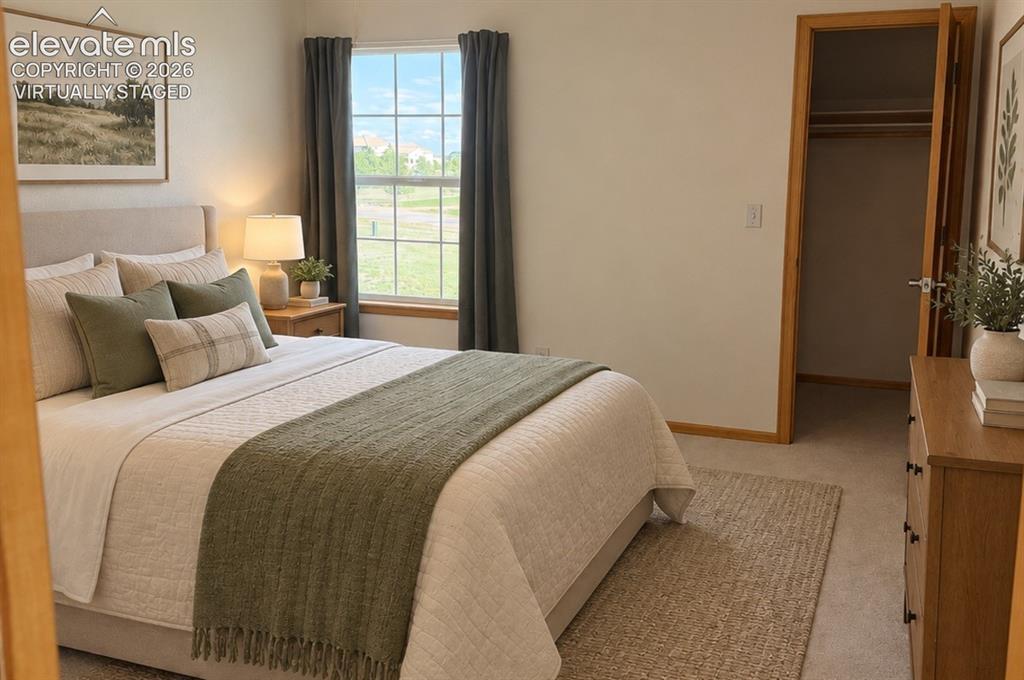 Image 27 of 48: Upstairs Bedroom 2/3 with walk-in closet, featuring a large window with gri