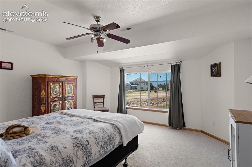 Image 32 of 47: Spacious room featuring vaulted ceilings, neutral carpeting, a large window