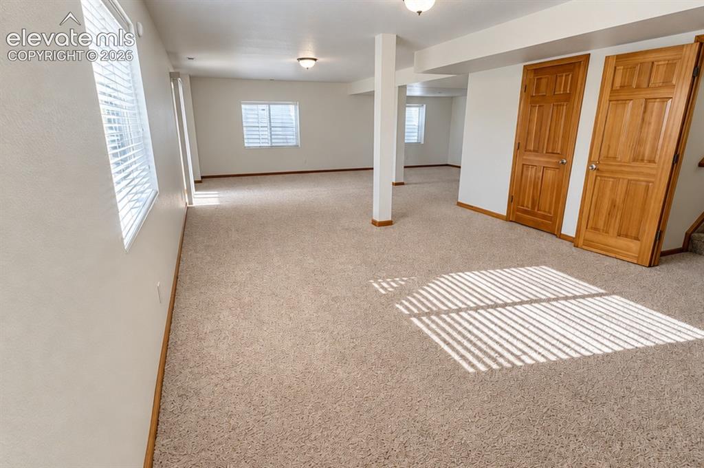 Image 34 of 48: Expansive carpeted area with multiple windows, recessed lighting, and solid