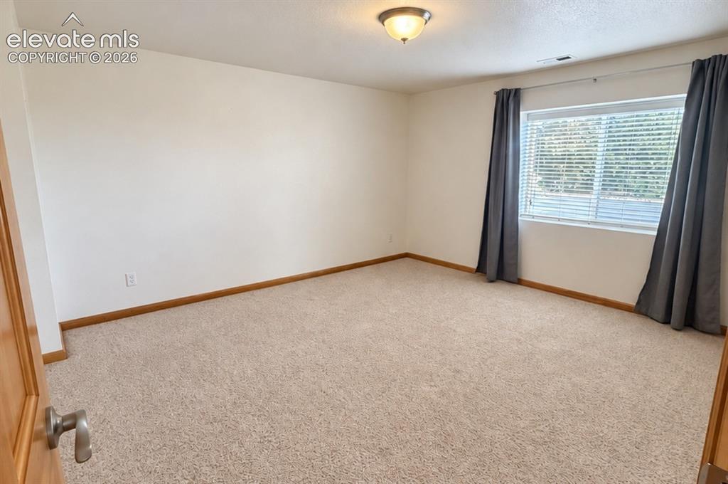Image 36 of 48: Carpeted room with a large window and a flush-mount ceiling light fixture