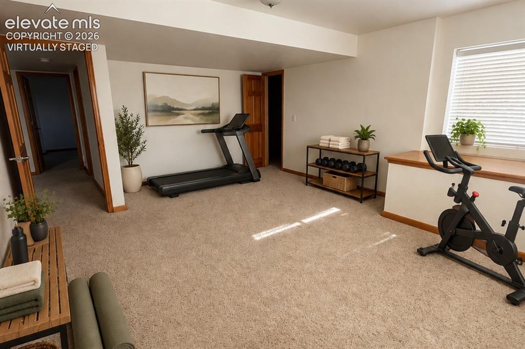 Image 38 of 48: Carpeted room featuring a window with blinds, wood-trim doorways, and a bui