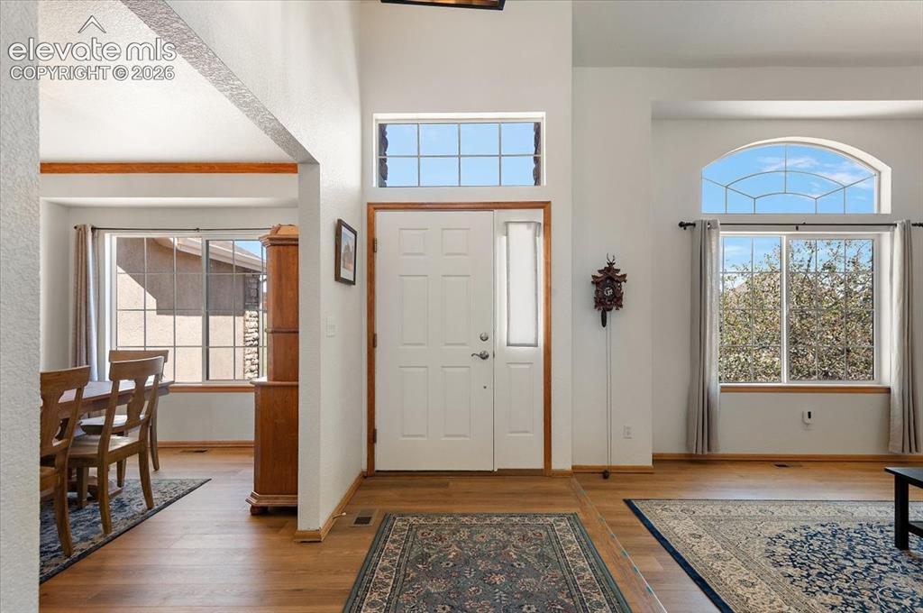 Image 4 of 47: Grand entryway featuring a white paneled door with a sidelight, transom win