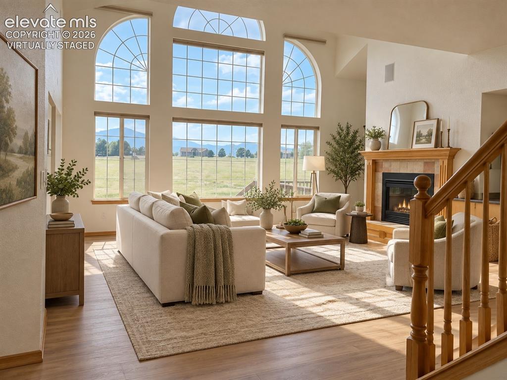 Image 4 of 48: Soaring vaulted ceiling with large arched windows, wood-finish flooring, bu