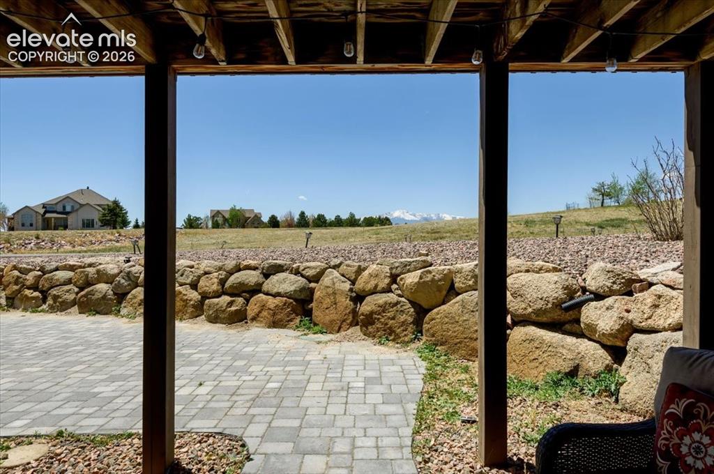 Image 40 of 47: Covered patio space featuring an exposed wood joist ceiling with string lig