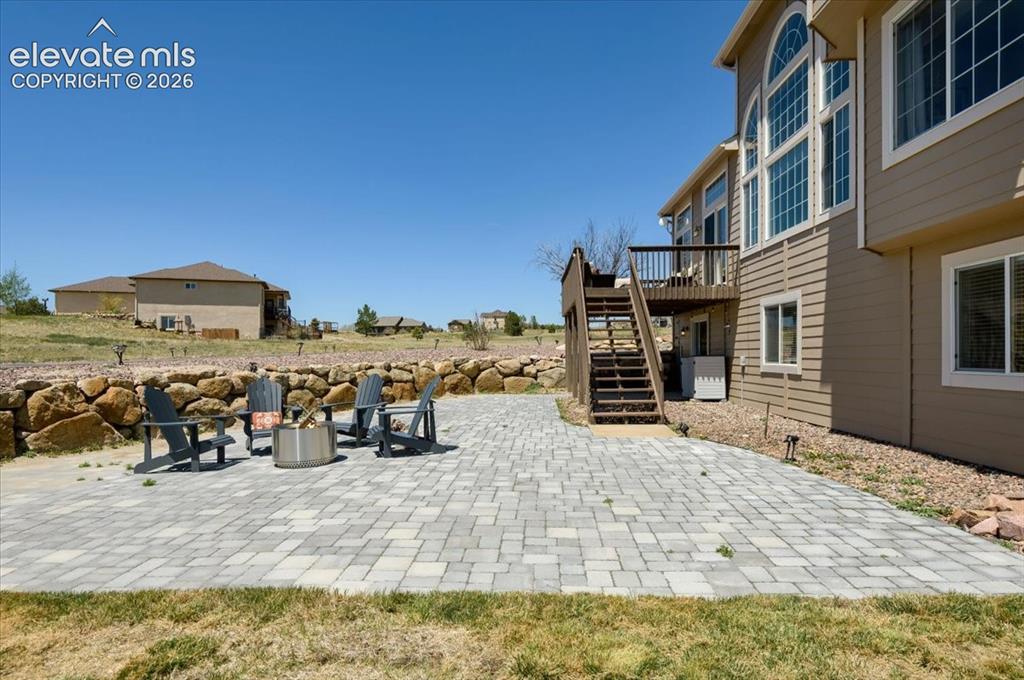 Image 41 of 47: Expansive paver patio featuring a stacked stone retaining wall