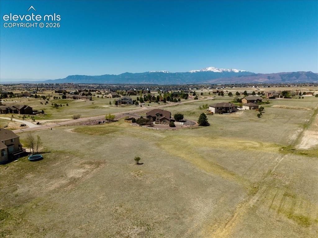 Image 46 of 50: Expansive undeveloped land with distant snow-capped mountain range, residen