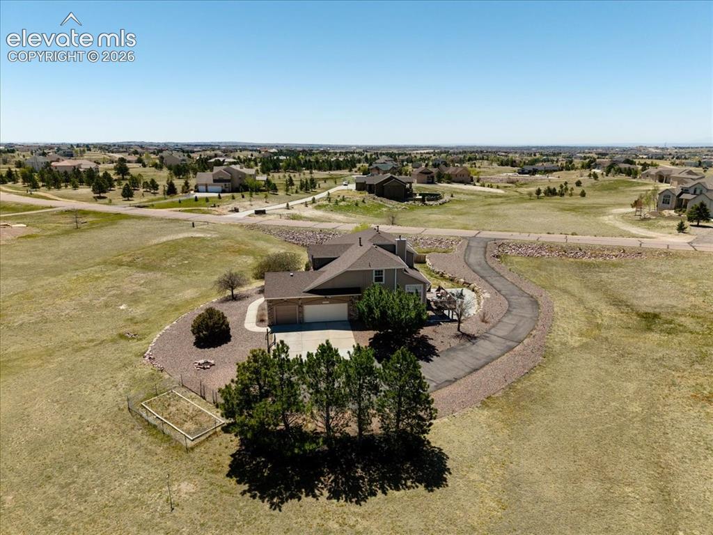 Image 46 of 47: Ranch-style home with an attached two-car garage, a long winding driveway,