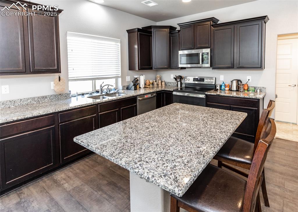 Image 12 of 40: Kitchen featuring appliances with stainless steel finishes, a kitchen break