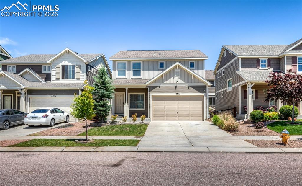 Image 2 of 40: View of front of property with driveway, board and batten siding, a garage,