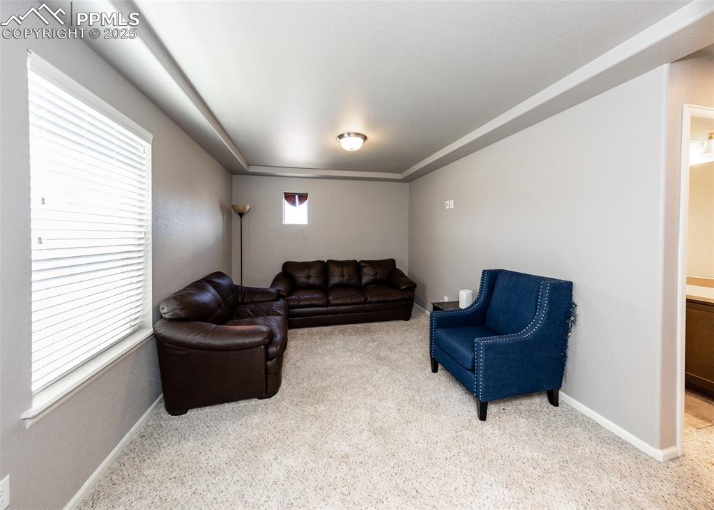 Image 22 of 40: Carpeted living area featuring baseboards