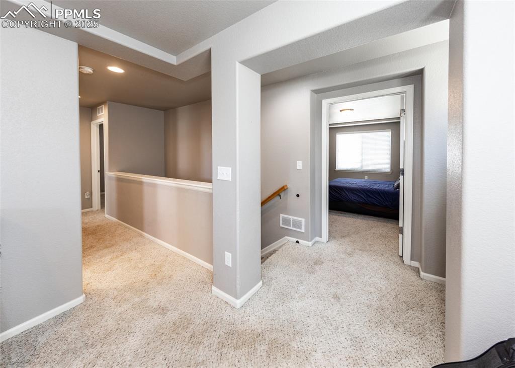 Image 25 of 40: Corridor with an upstairs landing, carpet flooring, and recessed lighting