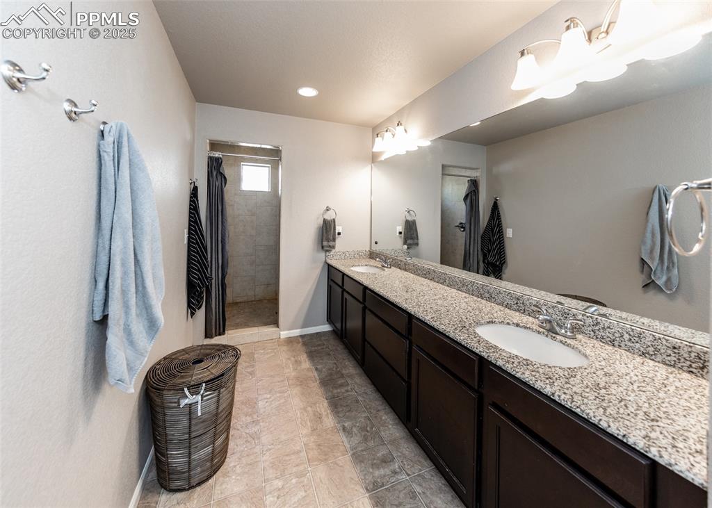 Image 30 of 40: Full bath featuring a tile shower, double vanity, and recessed lighting