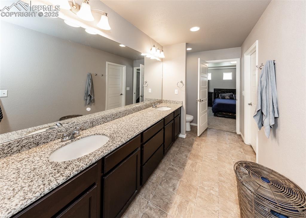 Image 31 of 40: Ensuite bathroom with double vanity and recessed lighting