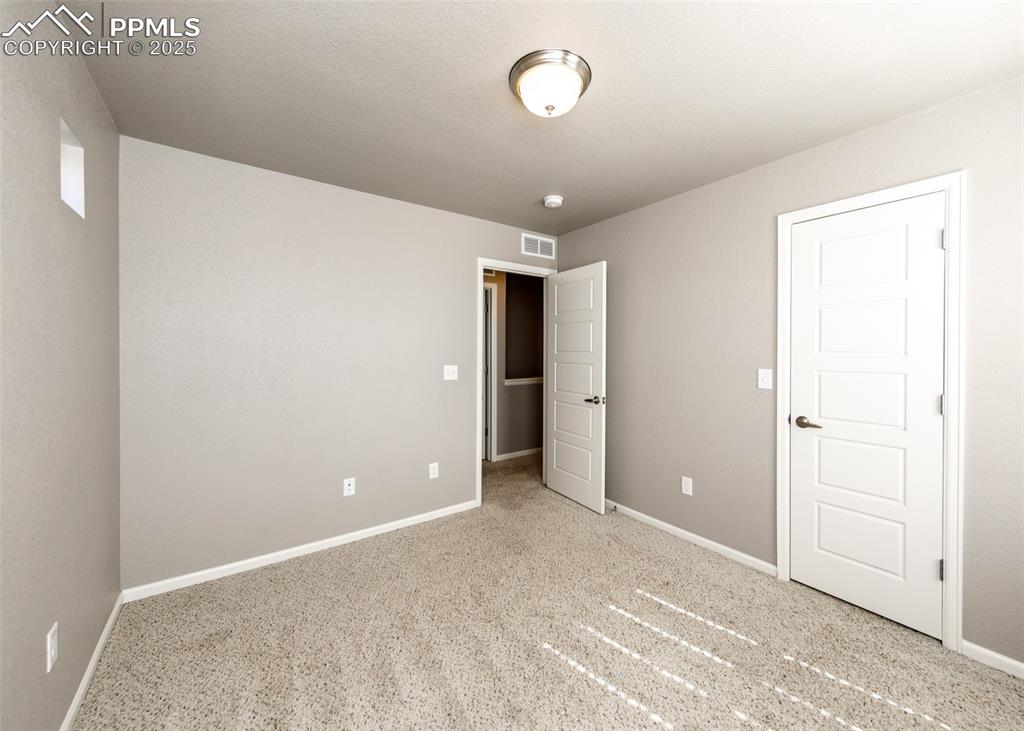 Image 44 of 50: Unfurnished bedroom featuring baseboards and carpet