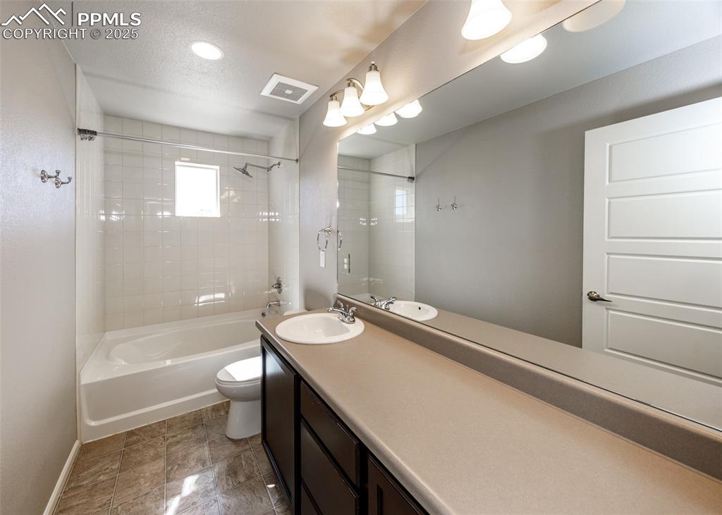Image 45 of 50: Bathroom featuring tub / shower combination, vanity, and a textured ceiling