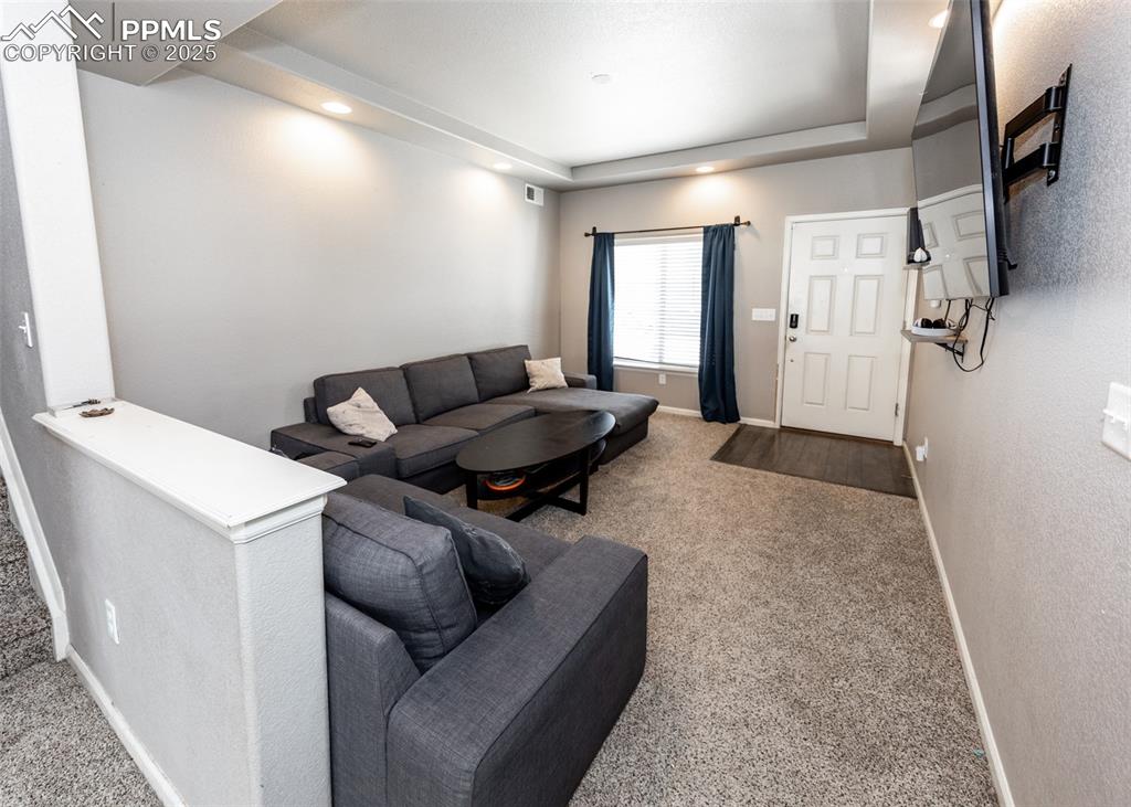 Image 6 of 40: Carpeted living room featuring a tray ceiling and recessed lighting
