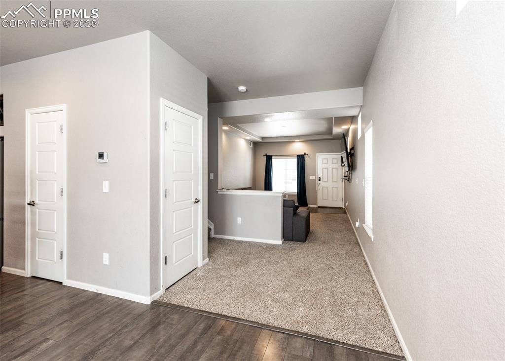 Image 9 of 40: Hallway featuring dark wood-style flooring and baseboards