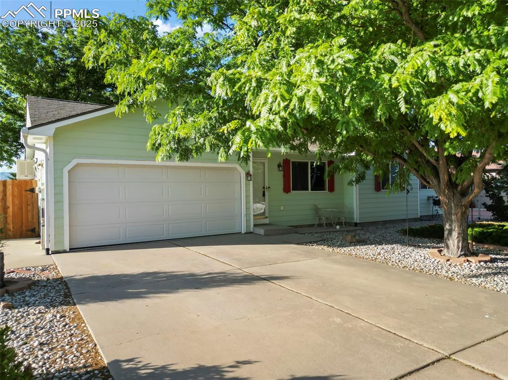 Caption: Obstructed view of property featuring concrete driveway and an attached garage