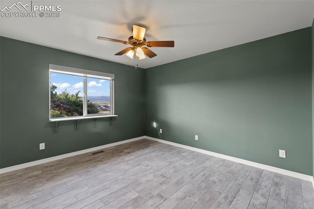 Image 14 of 27: Unfurnished room with ceiling fan and wood finished floors