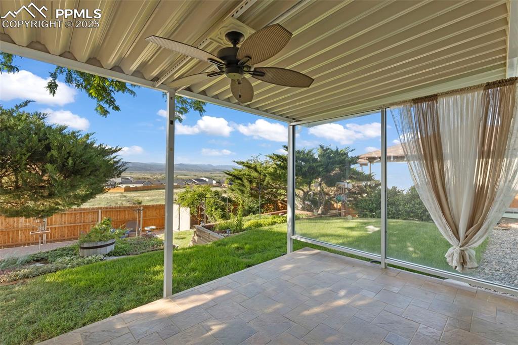 Image 18 of 27: Unfurnished sunroom with ceiling fan and a mountain view