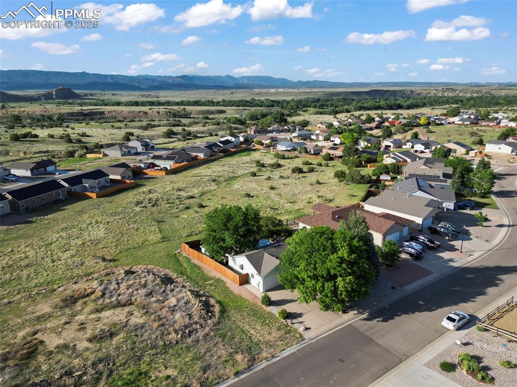 Image 24 of 27: Aerial perspective of suburban area featuring a mountain backdrop