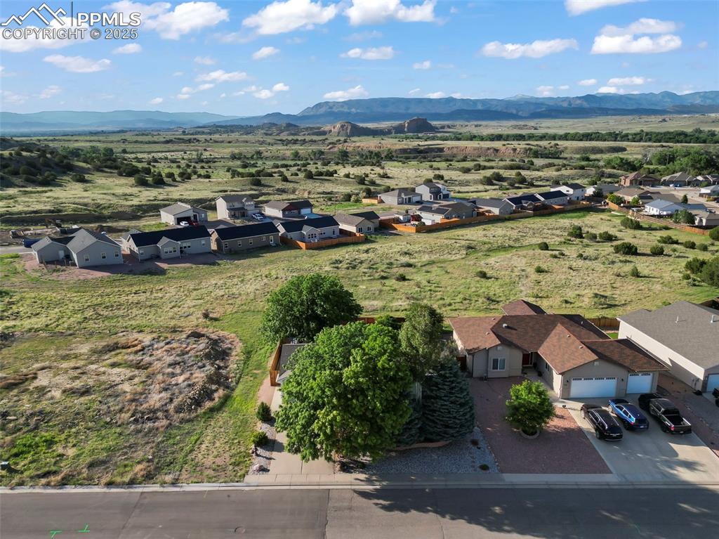Image 27 of 27: Aerial view of residential area featuring a mountainous background