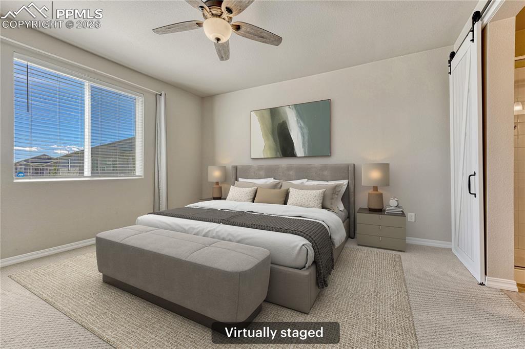 Image 15 of 42: This inviting bedroom features a ceiling fan, a large window with blinds, a