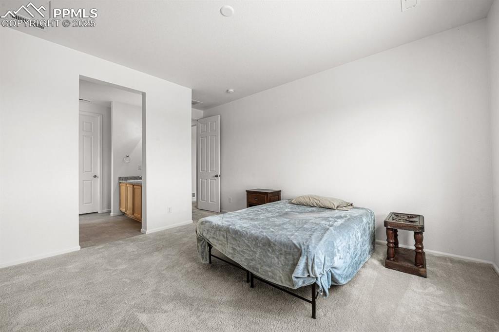 Image 13 of 25: Bedroom with light carpet and baseboards