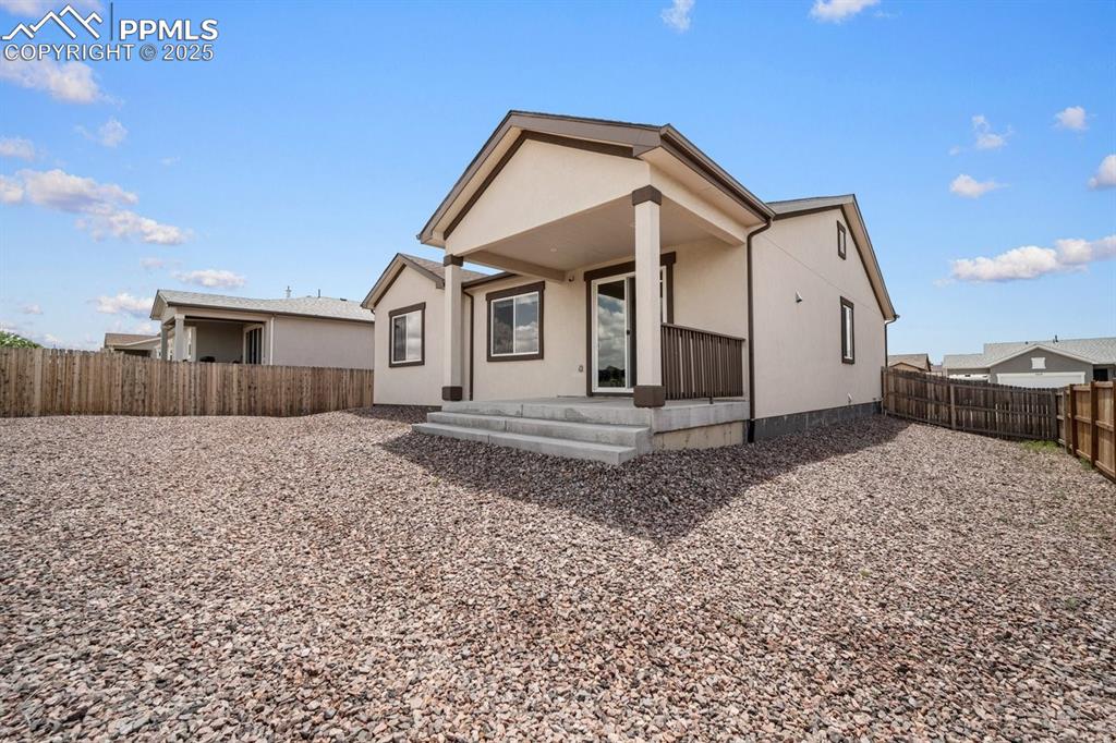 Image 22 of 25: Rear view of property with a fenced backyard and a porch