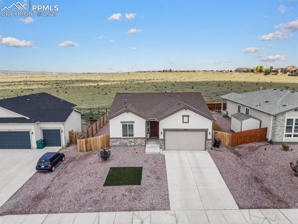 Image 23 of 25: Ranch-style home with driveway, stucco siding, an attached garage, and ston