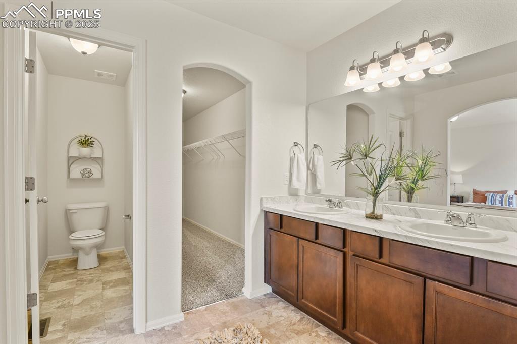 Image 23 of 36: Master Bath with view of closet and separate toilet