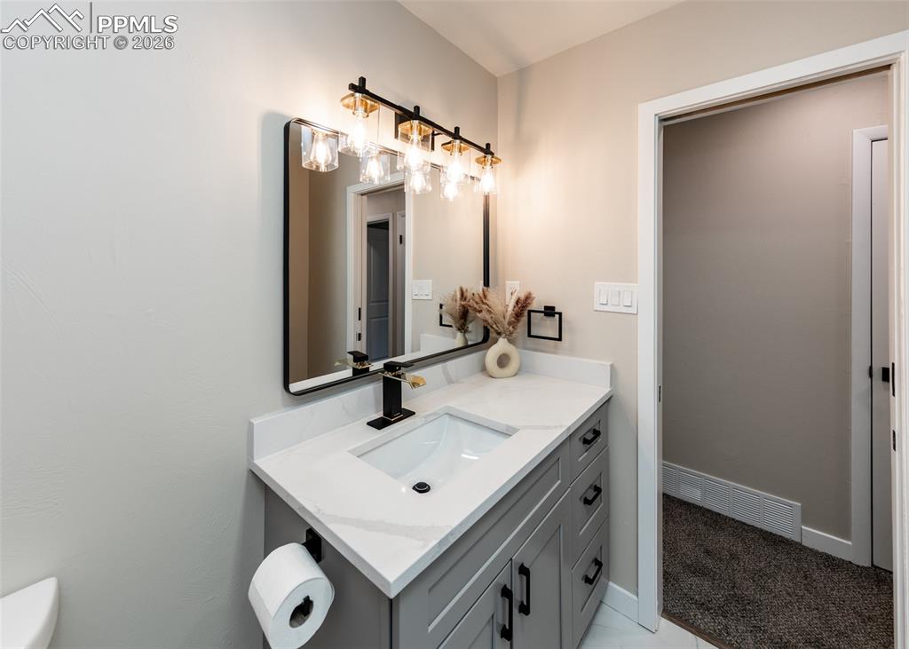 Image 30 of 48: Half bathroom featuring vanity and toilet