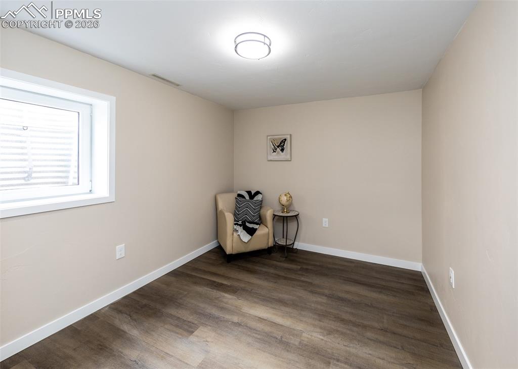 Image 35 of 48: Unfurnished room featuring dark wood-type flooring and baseboards