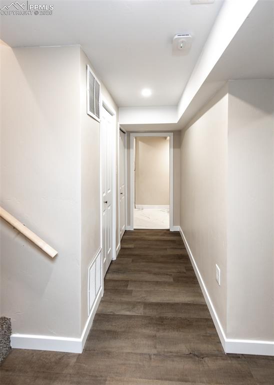 Image 37 of 48: Hallway with dark wood-style flooring and recessed lighting