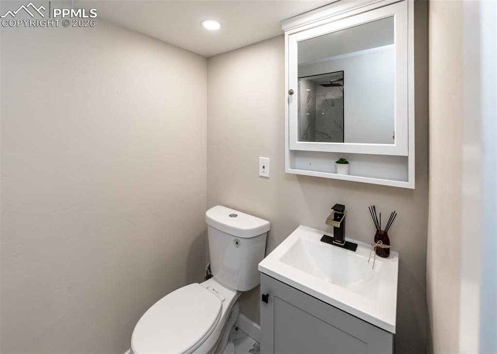 Image 38 of 48: Half bath featuring vanity, recessed lighting, and marble finish floors