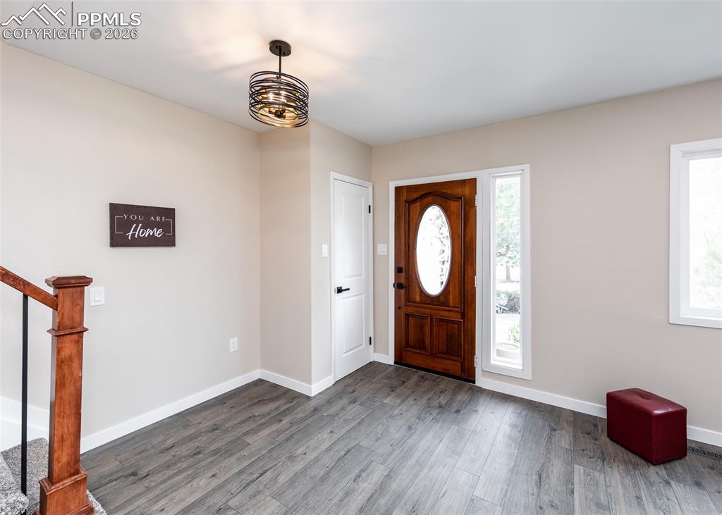Image 4 of 48: Entryway featuring wood finished floors and stairs