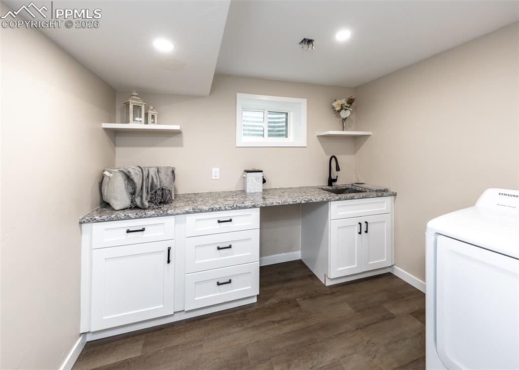 Image 40 of 48: Laundry room with washer / dryer, dark wood-type flooring, and cabinet spac