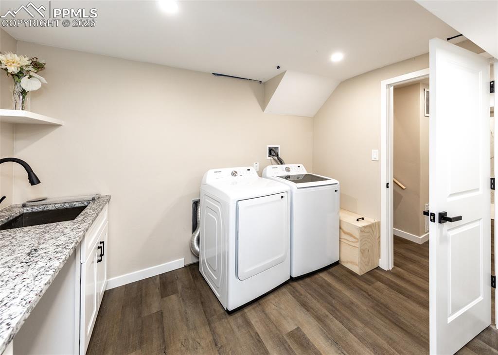 Image 41 of 48: Washroom with washing machine and dryer, dark wood-style flooring, recessed