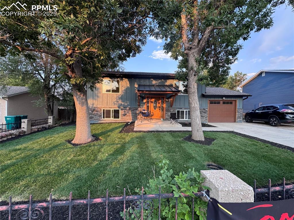 Image 1 of 36: View of front of house featuring stone siding, concrete driveway, a garage,