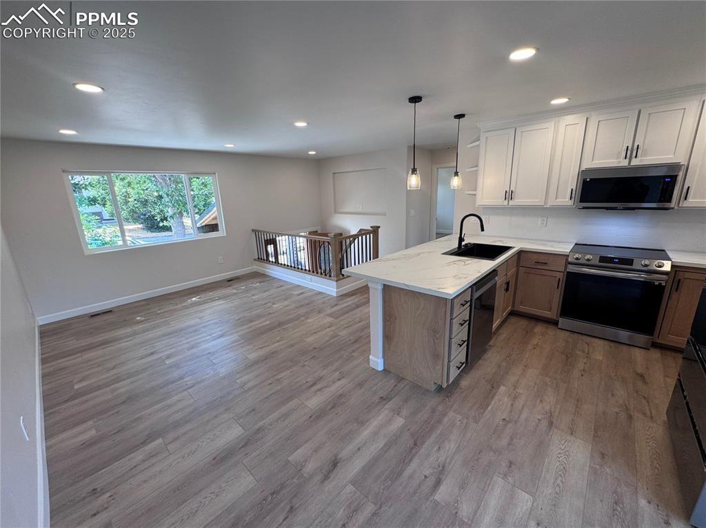Image 13 of 36: Kitchen featuring stainless steel appliances, hanging light fixtures, white