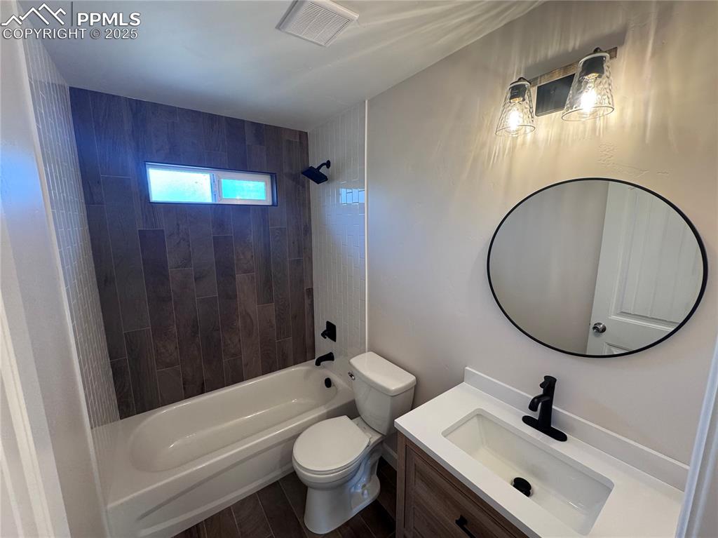 Image 14 of 36: Bathroom with shower / bathtub combination, vanity, and dark wood-style flo