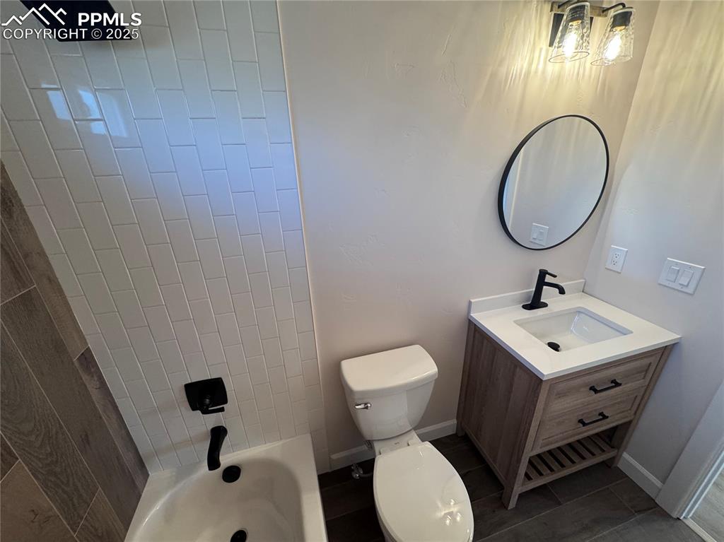Image 15 of 36: Full bathroom with vanity, shower / bathtub combination, and dark tile patt