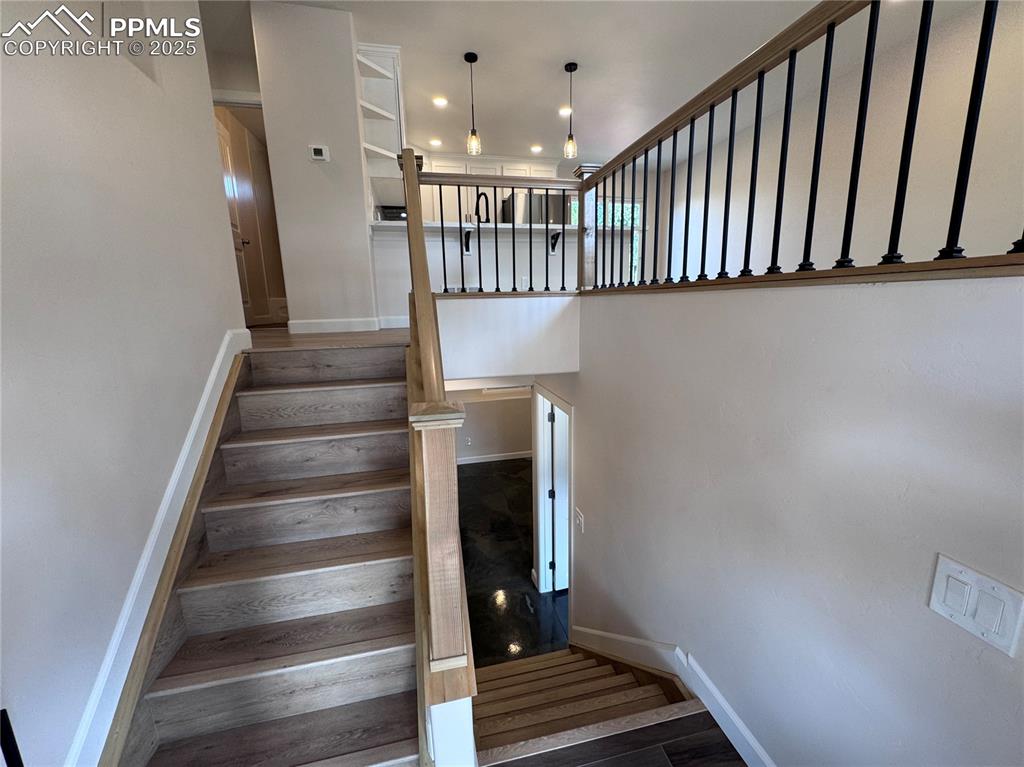Image 22 of 36: Stairway with wood finished floors and recessed lighting