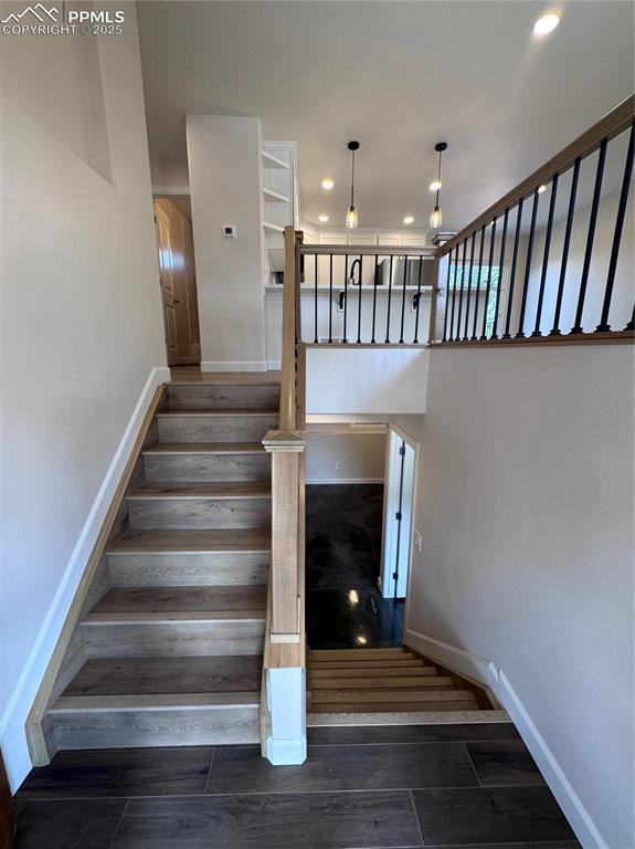Image 23 of 36: Stairway with wood finished floors and recessed lighting