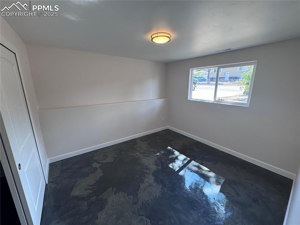 Image 25 of 36: Empty room with finished concrete flooring and baseboards