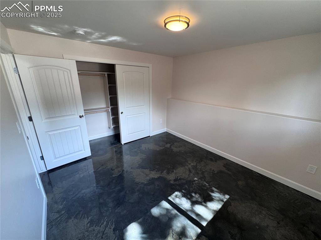 Image 26 of 36: Unfurnished bedroom with a closet and finished concrete floors