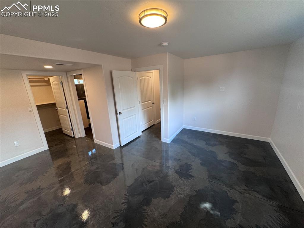 Image 29 of 36: Unfurnished bedroom featuring a spacious closet and concrete floors